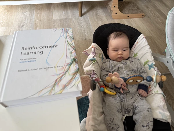 Florence in her bouncer, with Sutton and Barto on the table